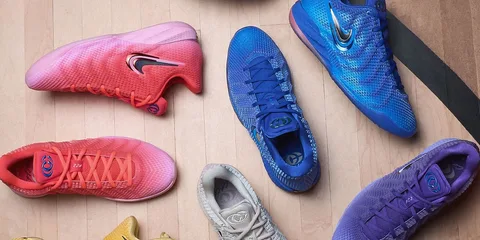 Différents modèles de baskets colorées sur un sol en bois.