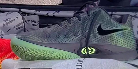 Chaussure de sport gris avec design moderne et semelle verte.