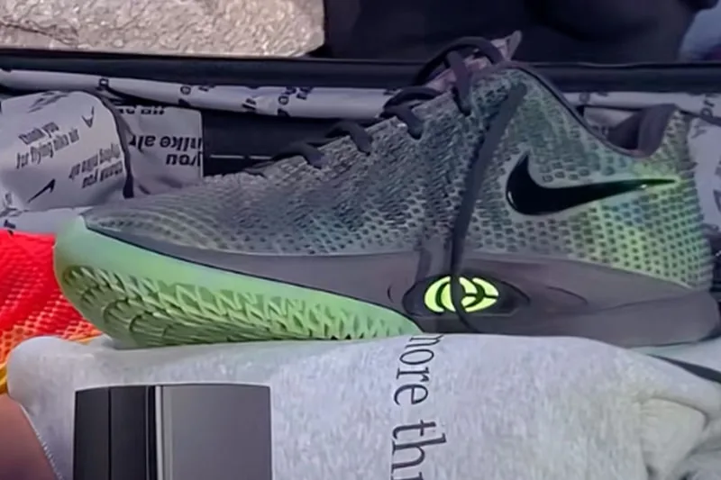 Basket Nike noire et verte avec un logo lumineux sur semelle.