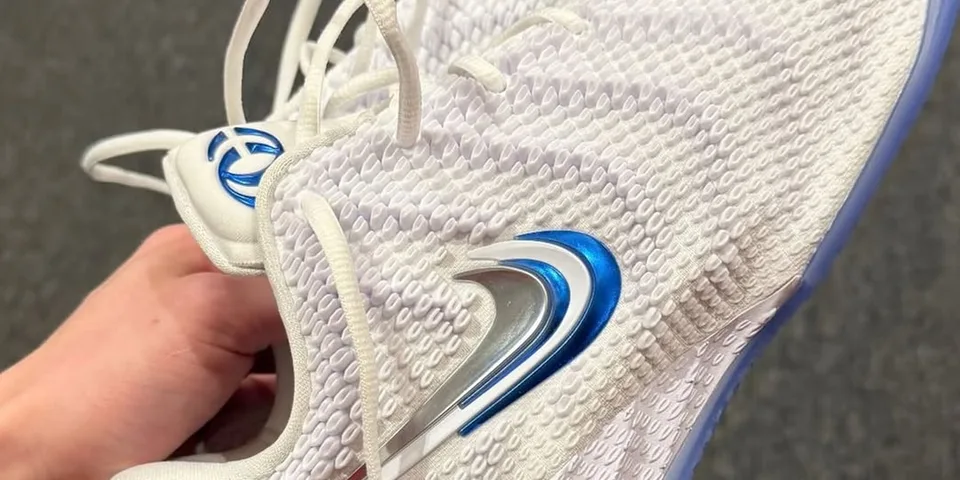 Chaussure blanche avec motifs et accents bleus.