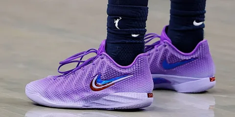 Chaussures de sport violettes avec motif Nike et chaussettes sombres.