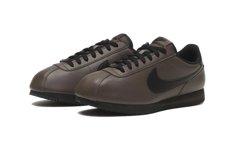 Chaussures de sport marron avec logo noir sur le côté, style rétro Nike Cortez.