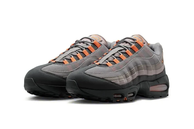 Chaussures de sport grises avec accents orange, vue de trois quarts.