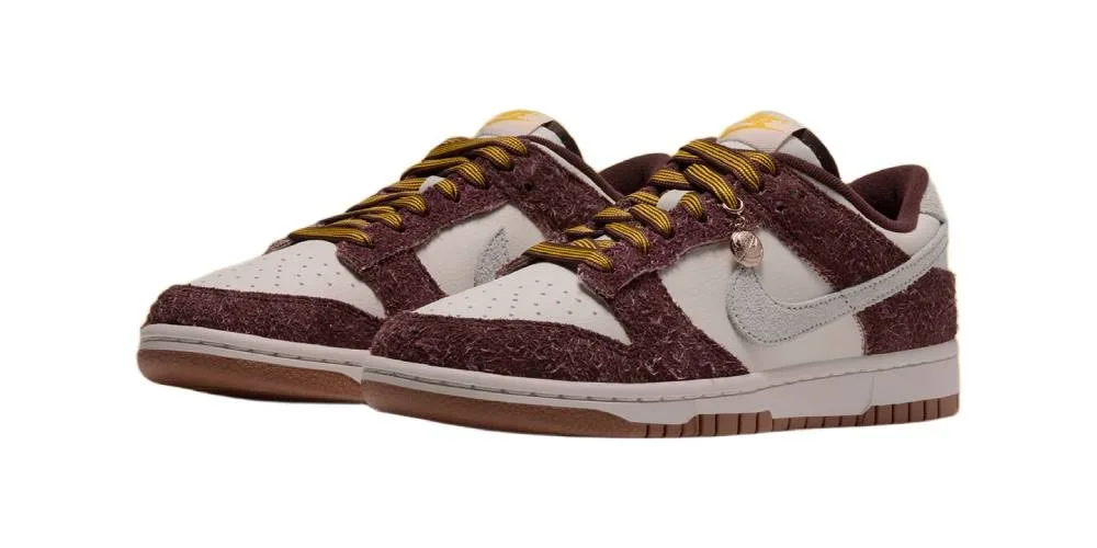Baskets Nike bordeaux et beige avec lacets jaunes, vues sur fond blanc.