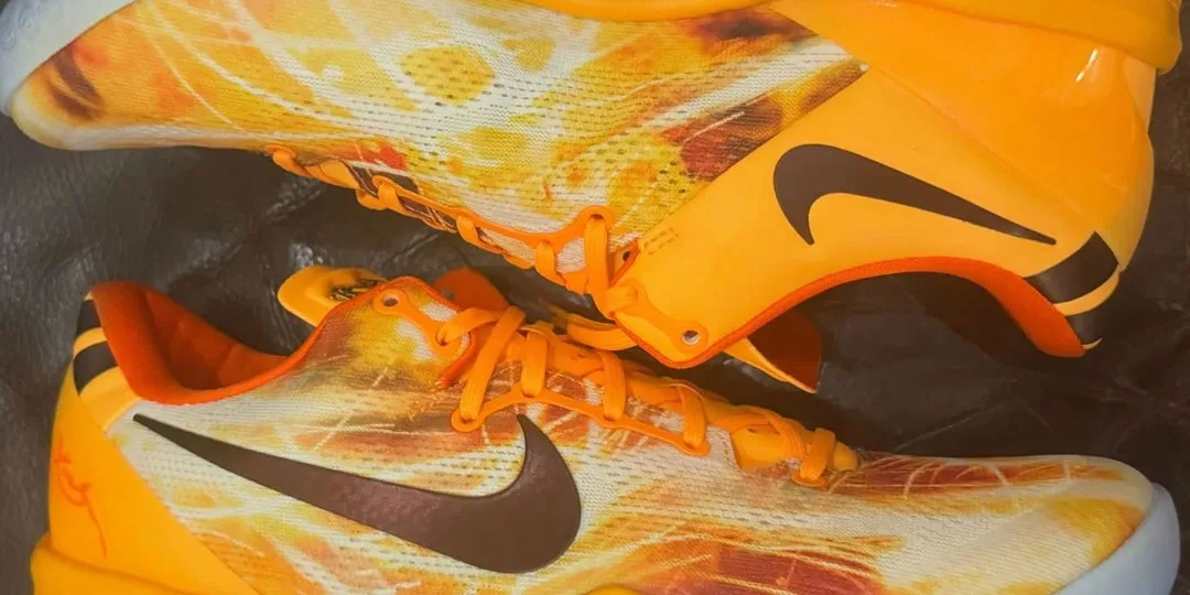 Chaussures de sport orange avec logo swoosh noir sur les côtés.