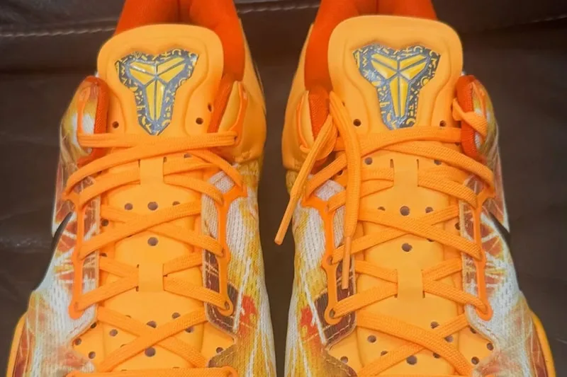 Chaussures orange avec logo sur la languette, lacets assortis.