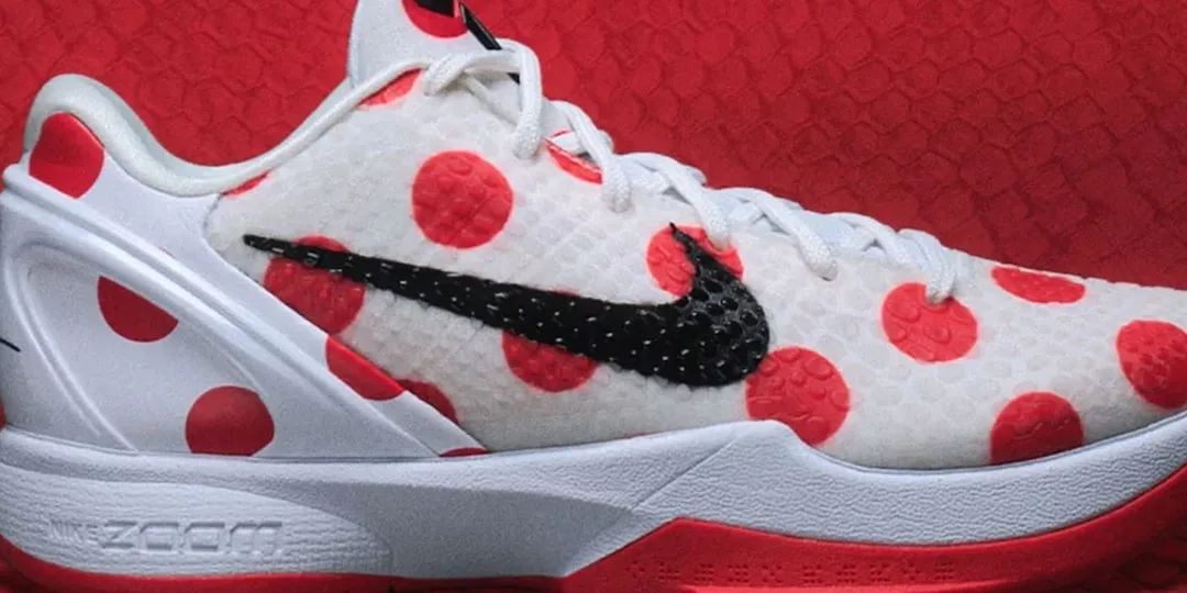 Chaussure avec motifs à pois rouges et logo noir sur fond blanc.