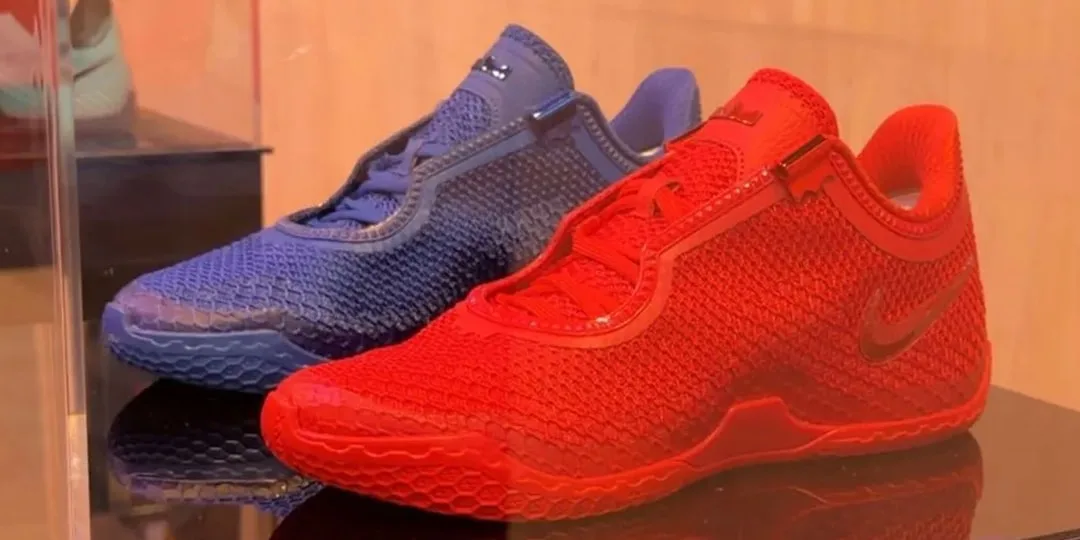 Deux chaussures de sport, l’une rouge et l’autre bleue, exposées sur une surface brillante.