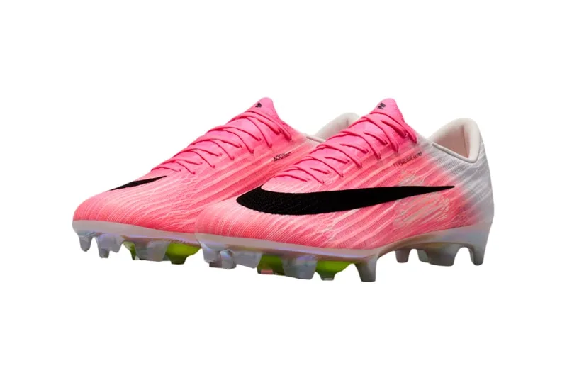 Chaussures de football rose et noir avec crampons visibles.