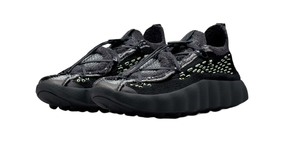 Paire de baskets noires à semelle épaisse avec détails vert clair.