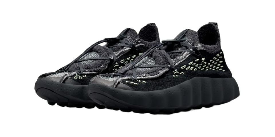 Paire de baskets noires à semelle épaisse avec détails vert clair.