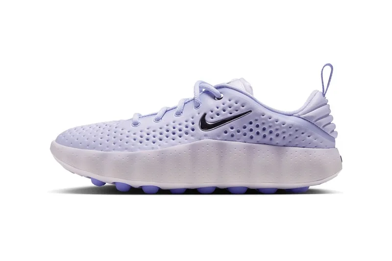 Chaussure violette avec logo noir sur le côté, semelle souple et perforations