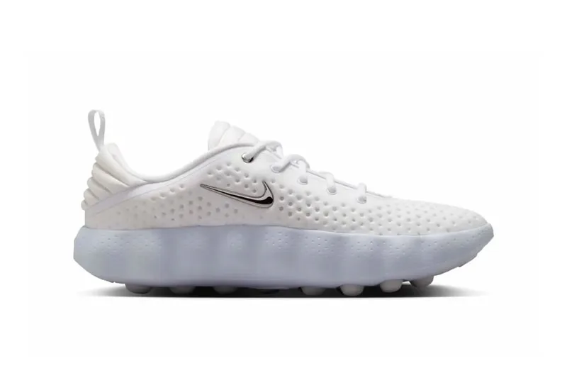 Basket Nike blanche avec semelle épaisse et Swoosh latéral argenté.