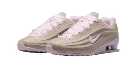 Chaussures beige et rose avec semelle et logo Nike, design futuriste.