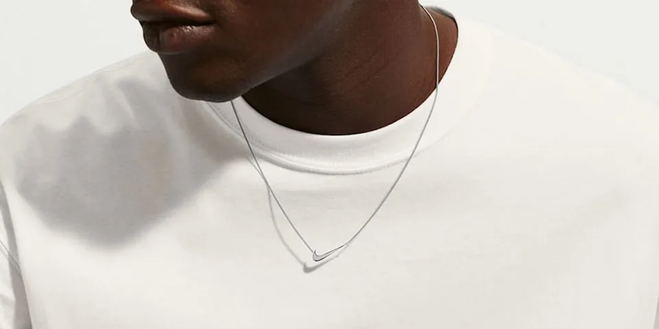 Homme avec collier et t-shirt blanc, gros plan