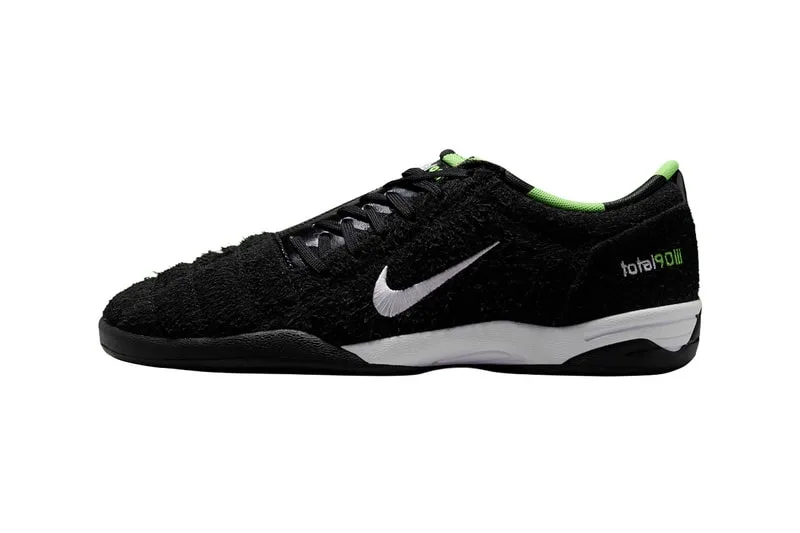 Chaussure noire et verte avec logo blanc sur le côté.