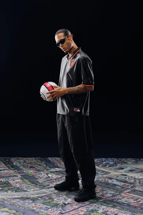 Homme avec ballon de football, lunettes, sur fond noir et carte.