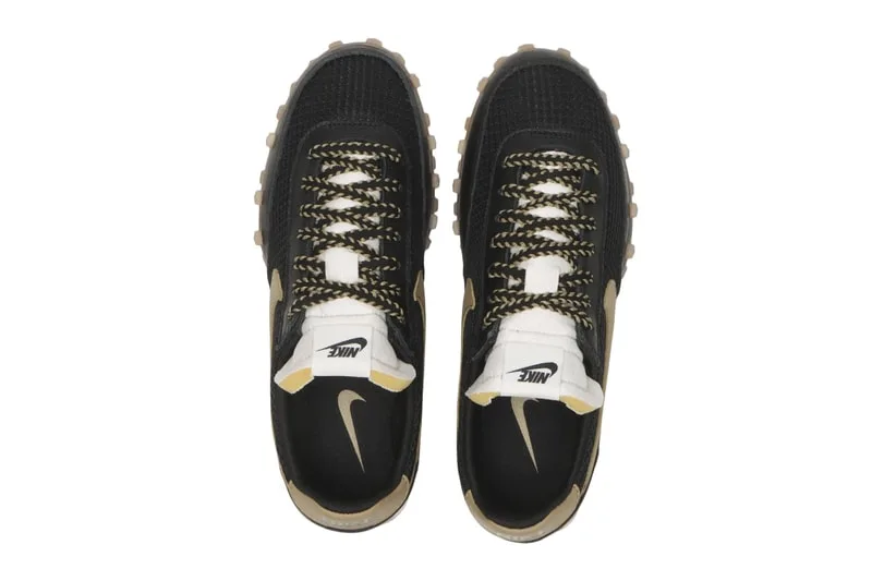 Vue de dessus de chaussures noires avec détails dorés et blanc.