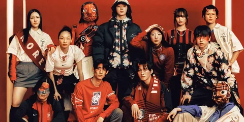 Groupe de personnes avec des tenues aux couleurs de la Corée du Sud, fond rouge.
