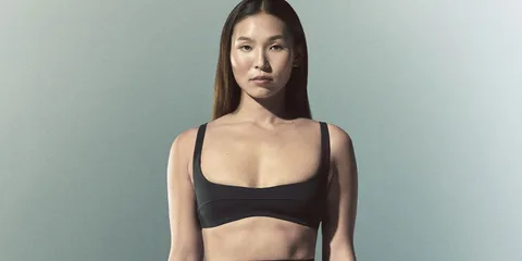 Femme en tenue de sport noire sur fond neutre
