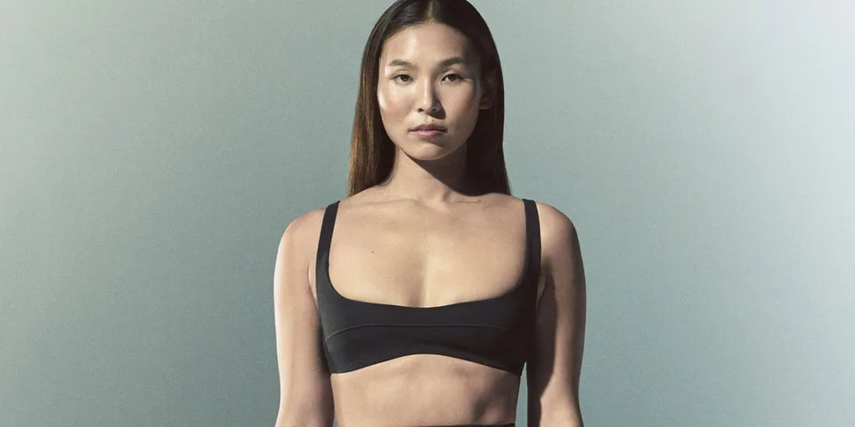 Femme en tenue de sport noire sur fond neutre