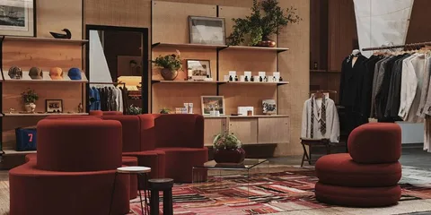 Boutique avec mobilier rouge et vêtements exposés sur des étagères.