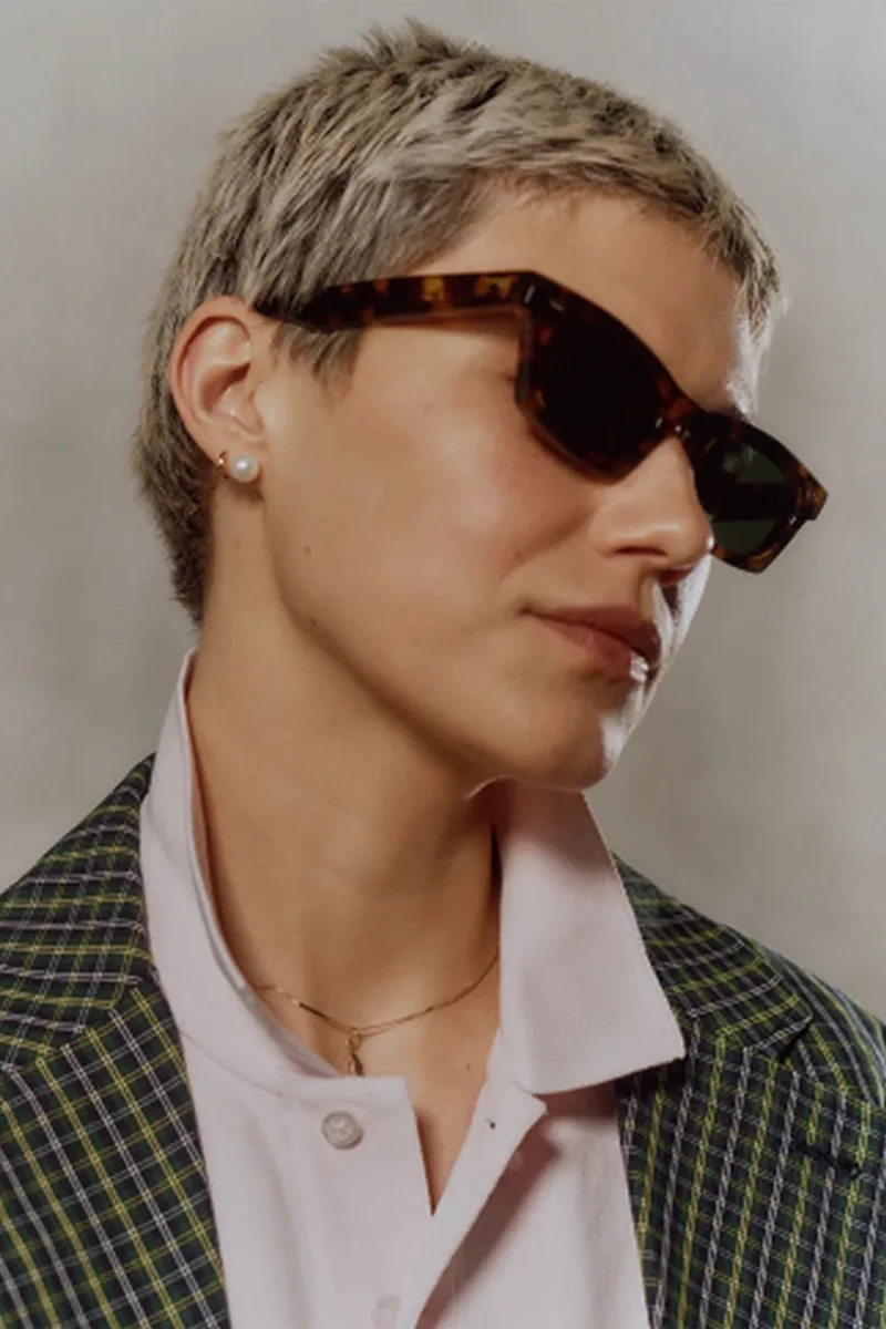 Personne portant des lunettes de soleil et une veste à carreaux