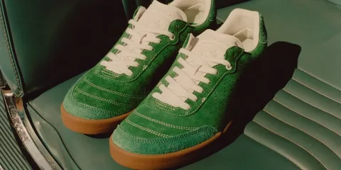 Chaussures vertes en daim avec semelle marron sur siège vert