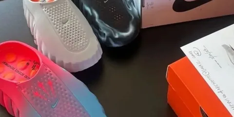 Trois paires de sabots colorés et une boîte Nike sur une table.