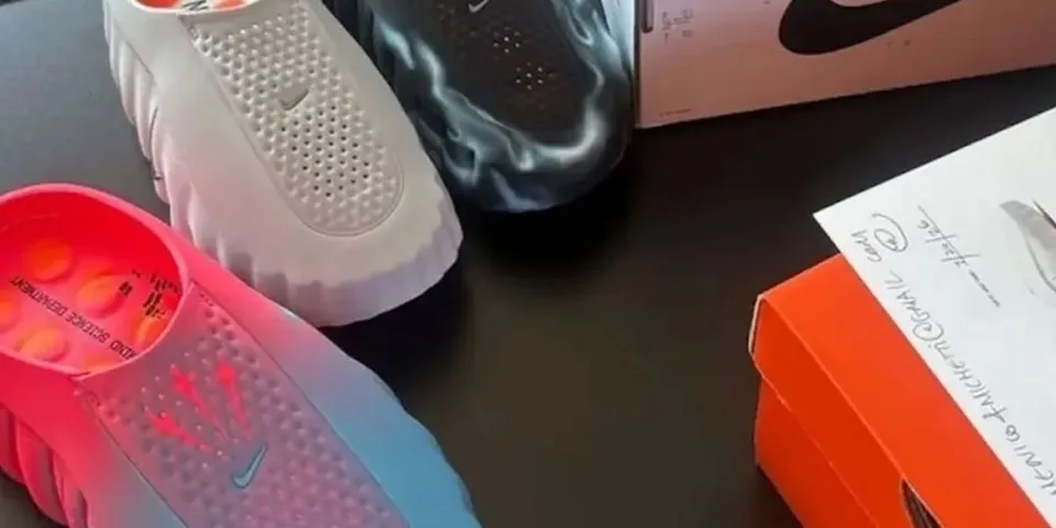 Trois paires de sabots colorés et une boîte Nike sur une table.