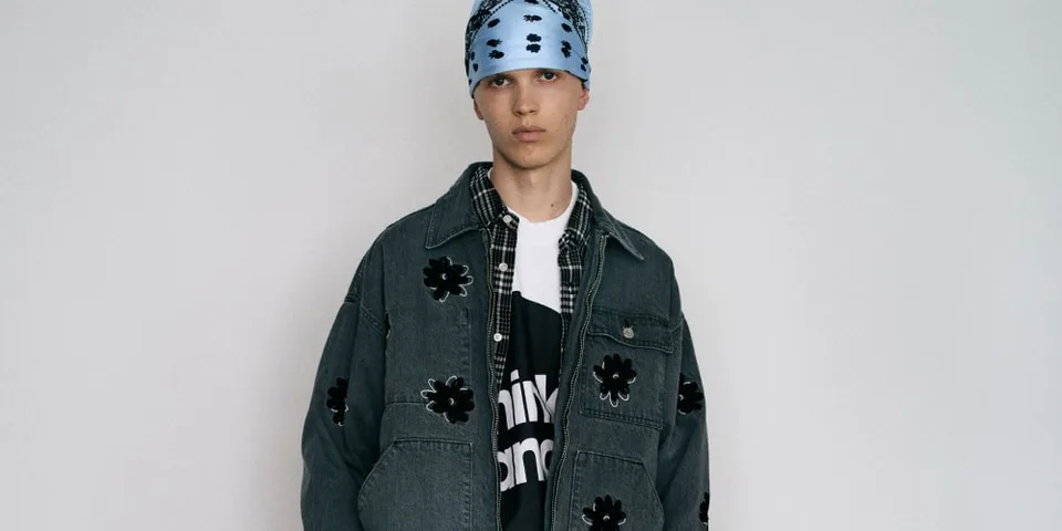 Personne portant une veste en jean avec fleurs noires et bandana bleu.
