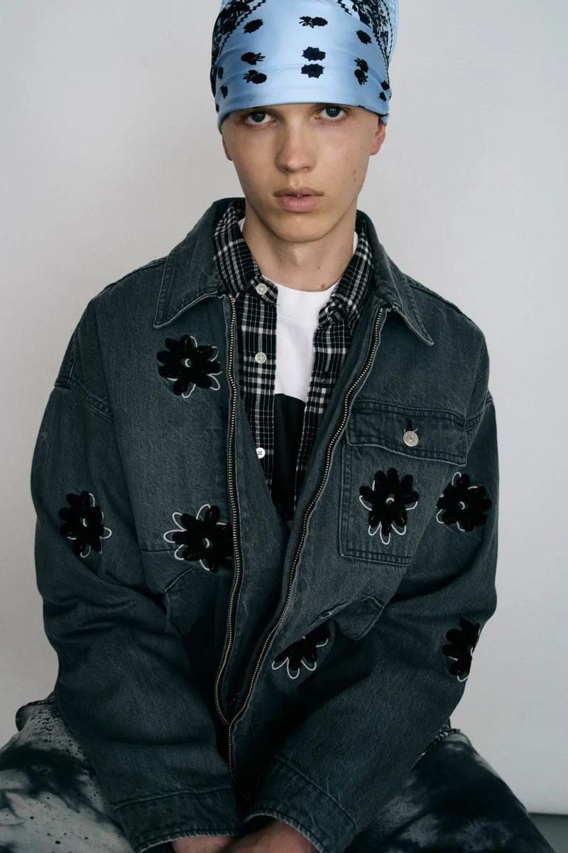 Homme avec veste et foulard bleu à motifs noirs.