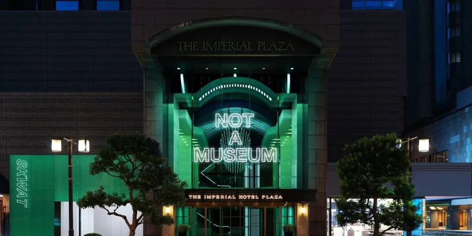 Entrée d'un bâtiment avec néon "NOT A MUSEUM".