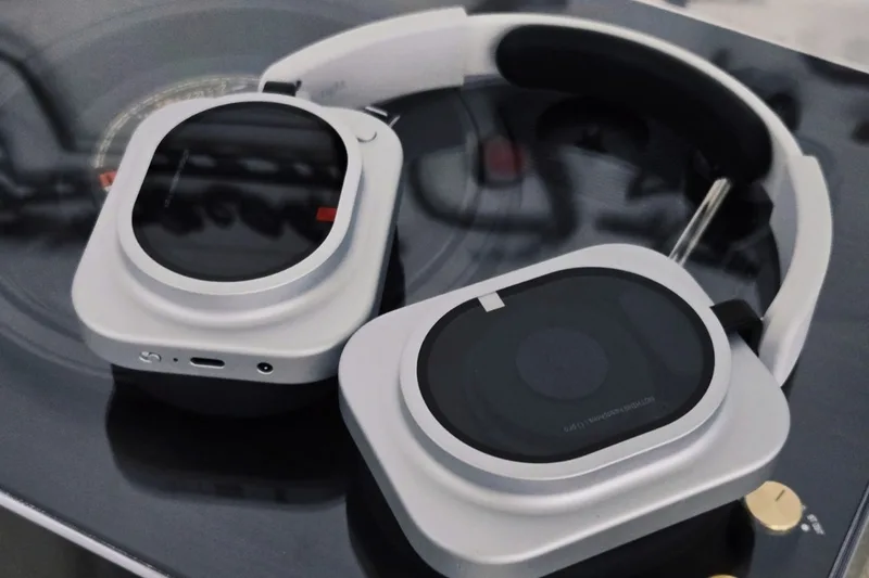 Casque audio moderne posé sur une surface réfléchissante.