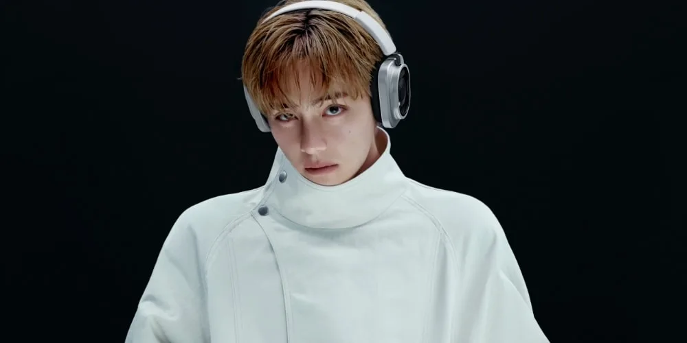 Personne avec un casque audio et un manteau blanc.