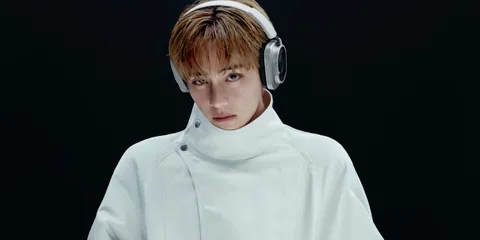 Personne avec un casque audio et un manteau blanc.