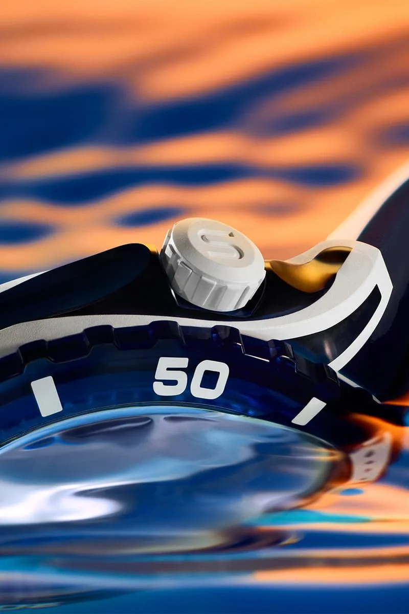 Gros plan d'une montre avec un cadran bleu et un fond orange aquatique.