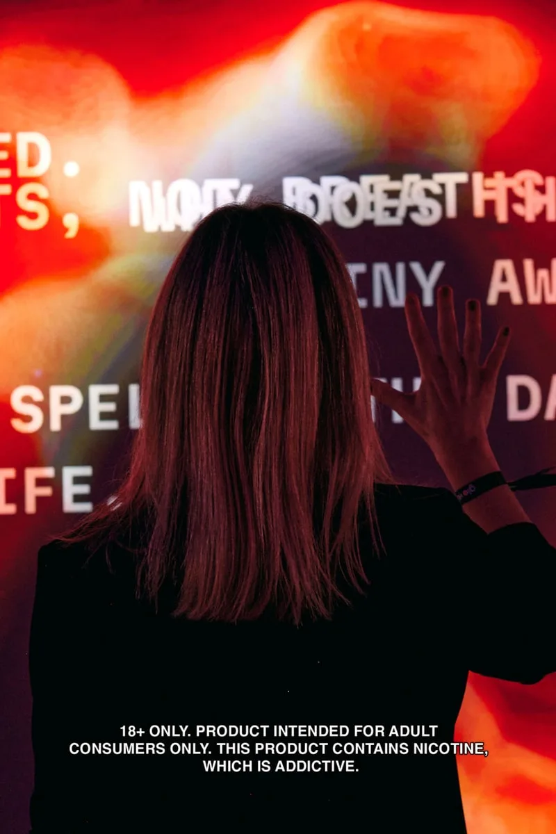 Femme de dos touchant un écran avec texte flou et lumineux en arrière-plan.