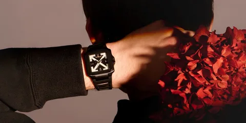 Personne avec montre noire et fleurs rouges