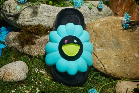 Sandale avec fleur bleue et pierres, décor naturel, style ludique.
