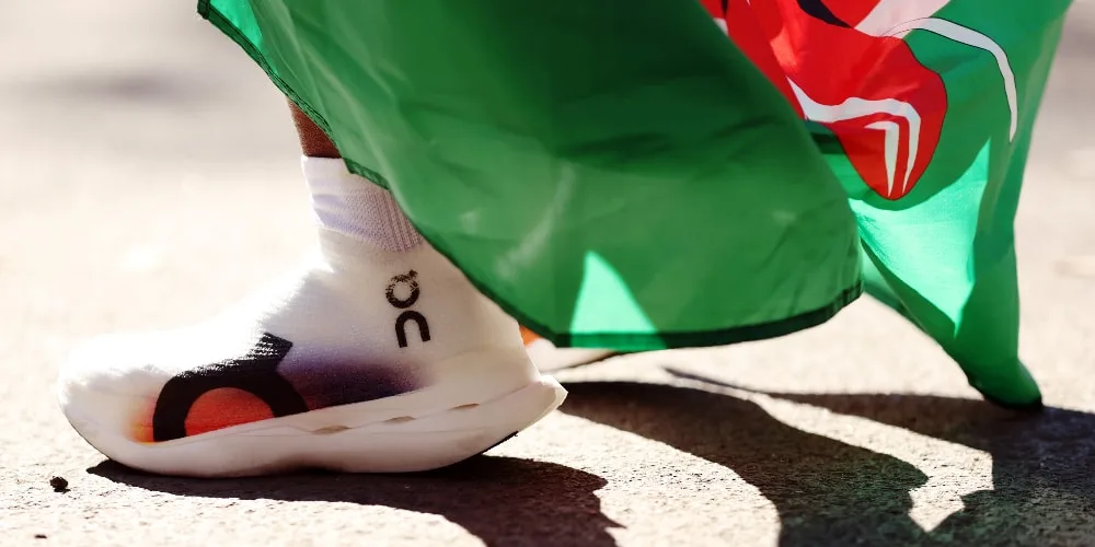 Gros plan sur une chaussure sportive blanche avec un drapeau vert.