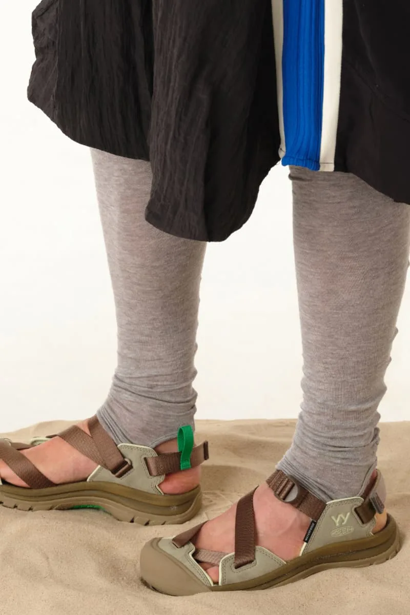 Personne portant des sandales et des leggings sur du sable