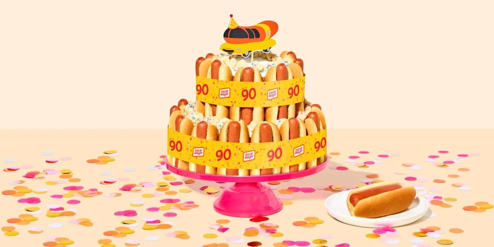 Gâteau original avec des hot-dogs et un ornement de voiture sur le dessus.