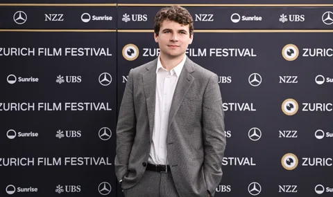 Homme en costume gris lors du Zurich Film Festival.