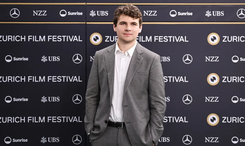 Homme en costume gris lors du Zurich Film Festival.