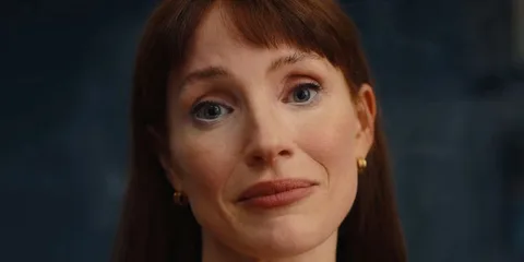 Femme souriante aux cheveux roux et boucles d'oreilles dorées
