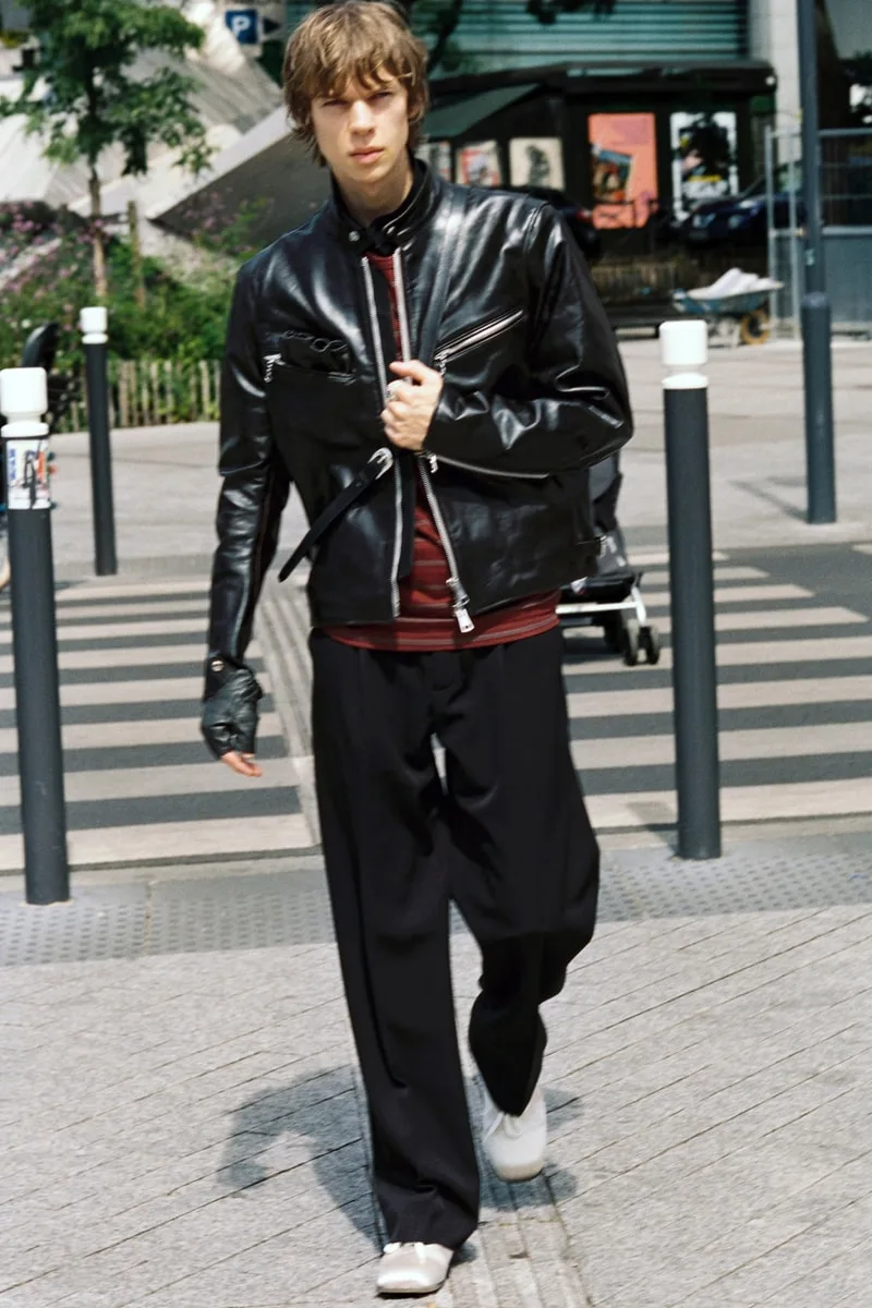 Homme avec blouson cuir noir et pantalon ample dans la rue