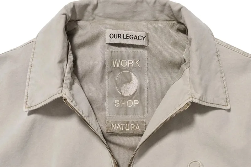 Étiquette de col d'un vêtement avec texte 'OUR LEGACY WORK SHOP NATURA'.