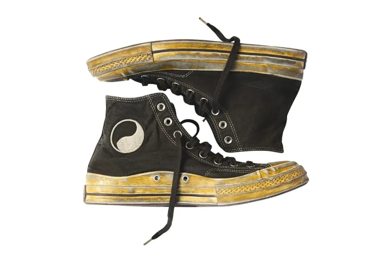 Chaussures montantes noires avec motif yin-yang et semelle dorée jaunie.
