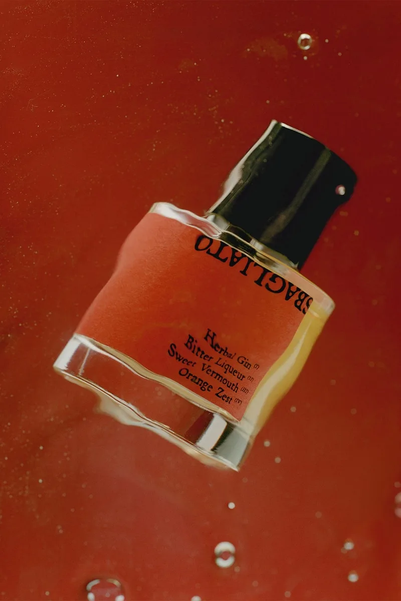 Flacon de parfum sur fond rouge.